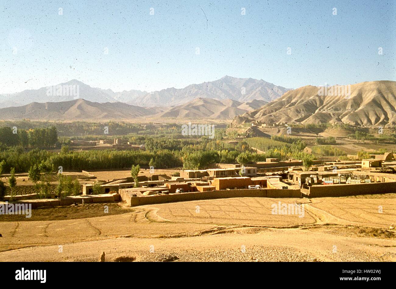 Panoramic view of the Hindu Kush mountains framing the small houses in valley town of Bamiyan, located in the Hazarajat region of central Afghanistan, November, 1975. Stock Photo