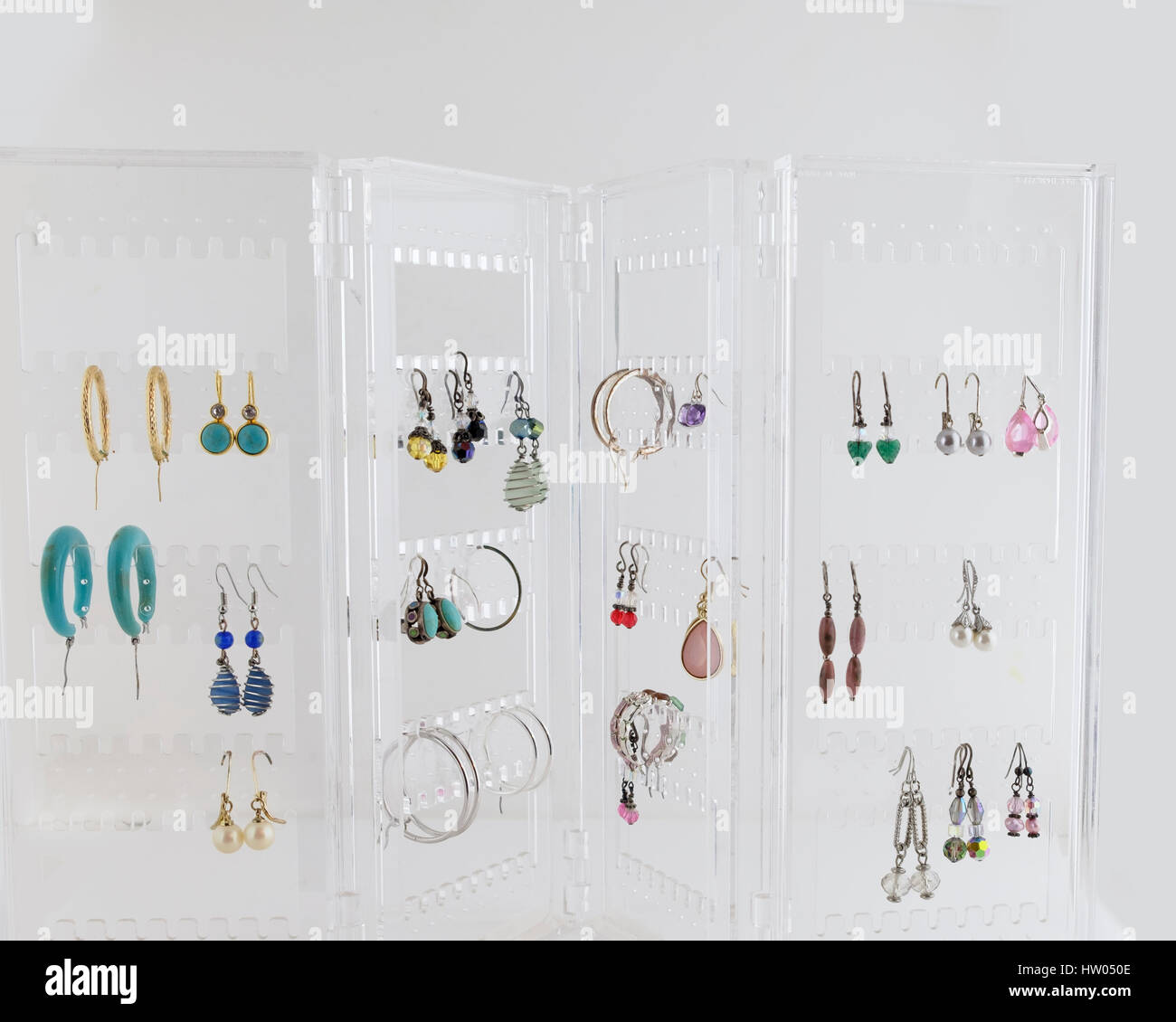 Acrylic foldable earring stand holding many pairs of earrings. Jewelry, bling. Stock Photo