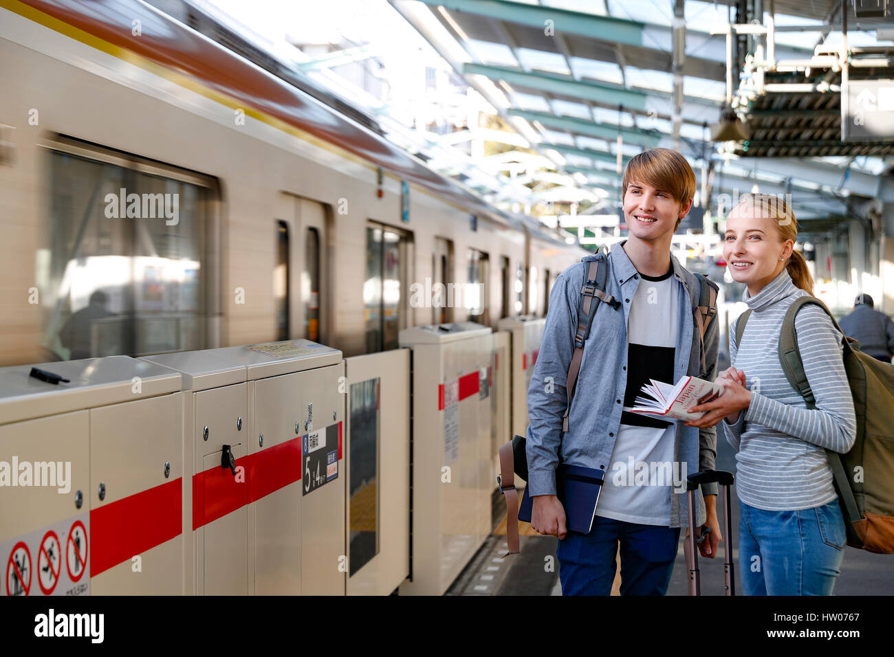 Caucasian tourist couple at train station, Tokyo, Japan Stock Photo