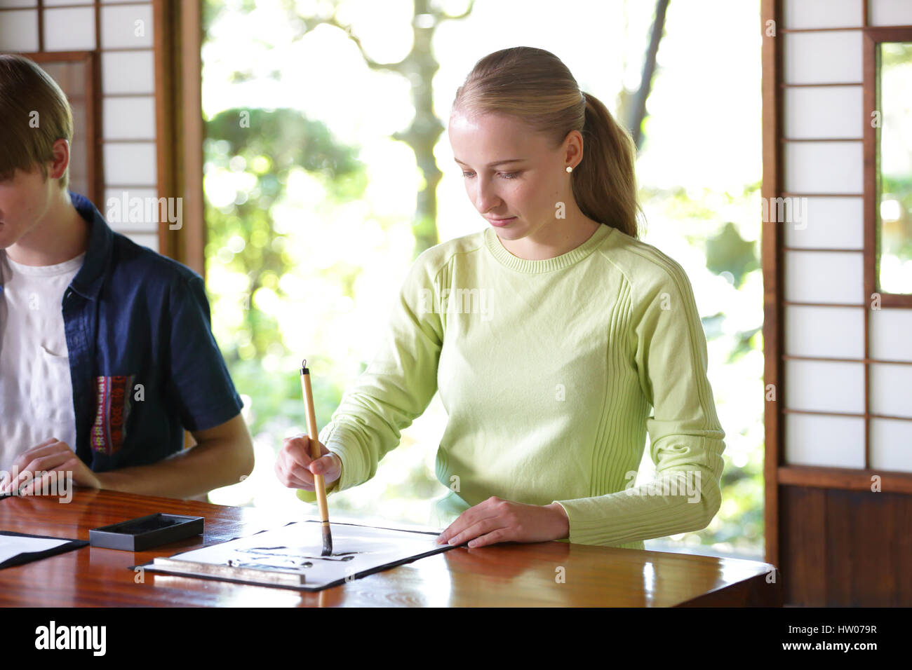 Caucasian couple practicing calligraphy at traditional Japanese house Stock Photo
