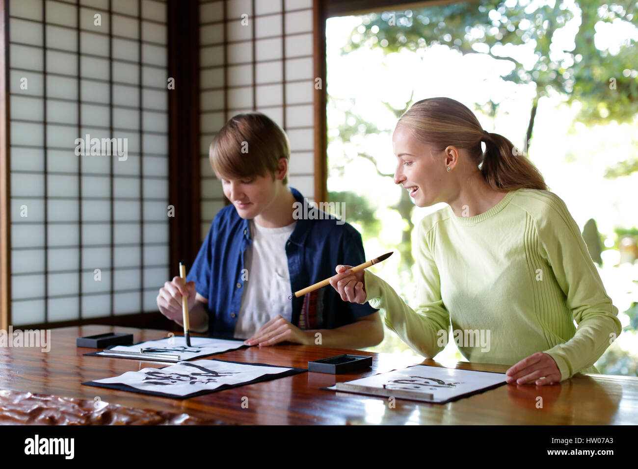 Caucasian couple practicing calligraphy at traditional Japanese house Stock Photo