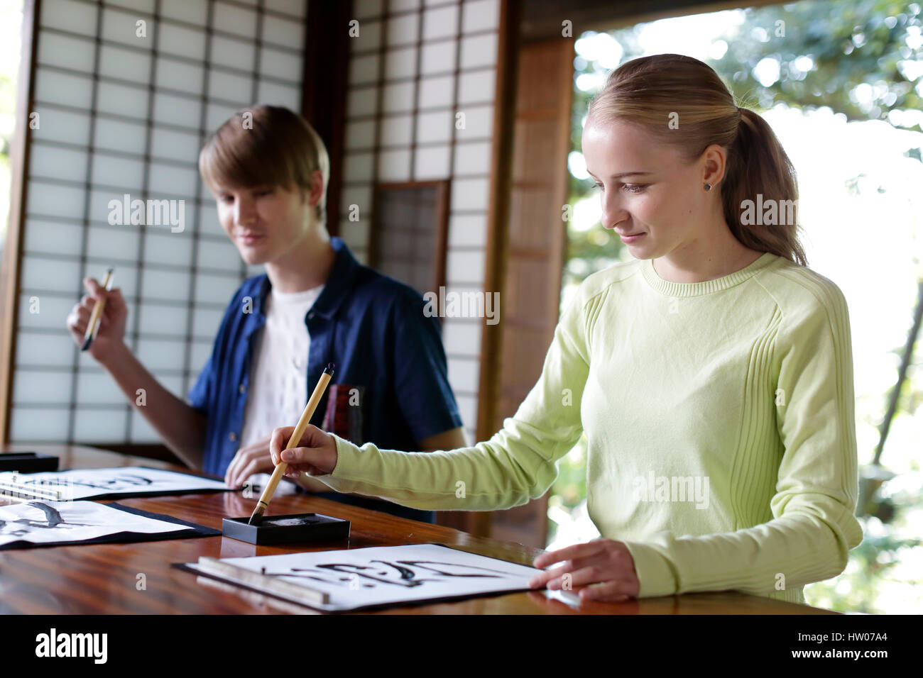 Caucasian couple practicing calligraphy at traditional Japanese house Stock Photo