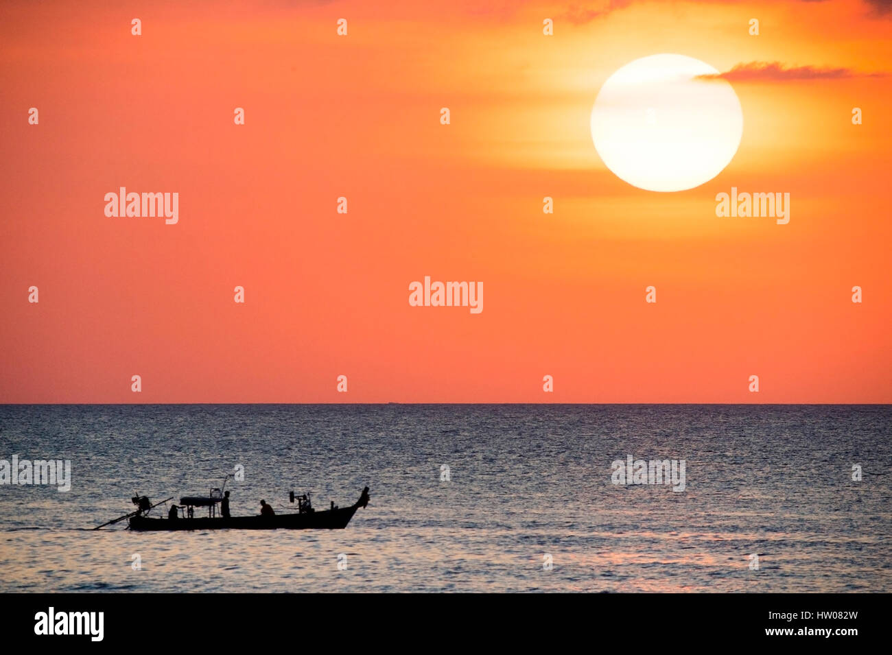 Big sun and a fisherman boat at sunset in Phuket - Thailand Stock Photo ...