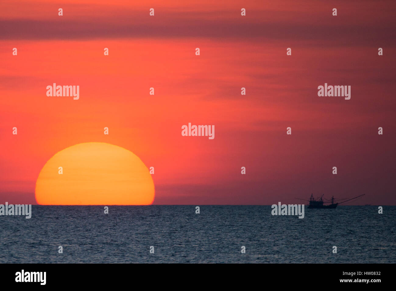 Big sun and a fisherman boat at sunset in Phuket - Thailand Stock Photo ...