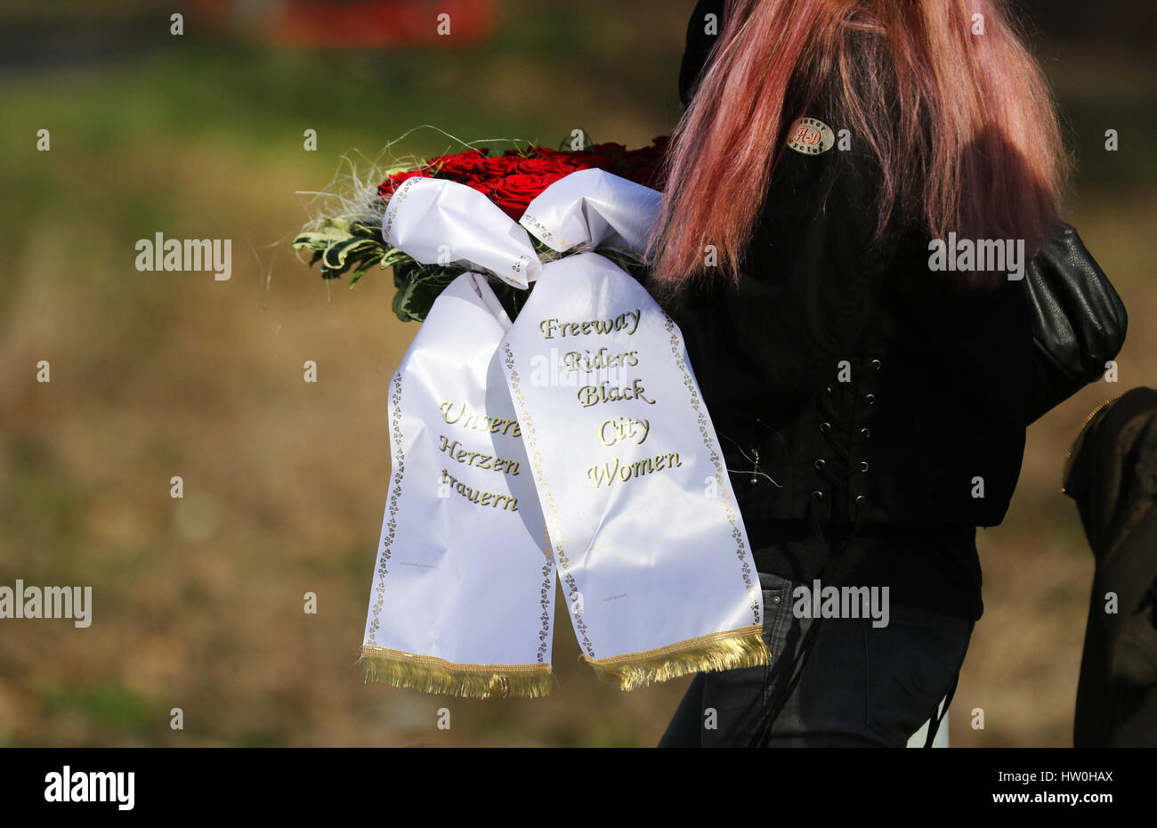 Herten, Germany. 16th Mar, 2017. A woman carries a wreath reading 'Unsere Herzen trauern' (lit. 'Our hearts mourn') and 'Freeway Riders Black City Women' at the burial of nine-year-old Jaden, one of the two victims of the double homicide of Herne, in Herten, Germany, 16 March 2017. A 19-year-old confessed to the two murders. Photo: Ina Fassbender/dpa/Alamy Live News Stock Photo