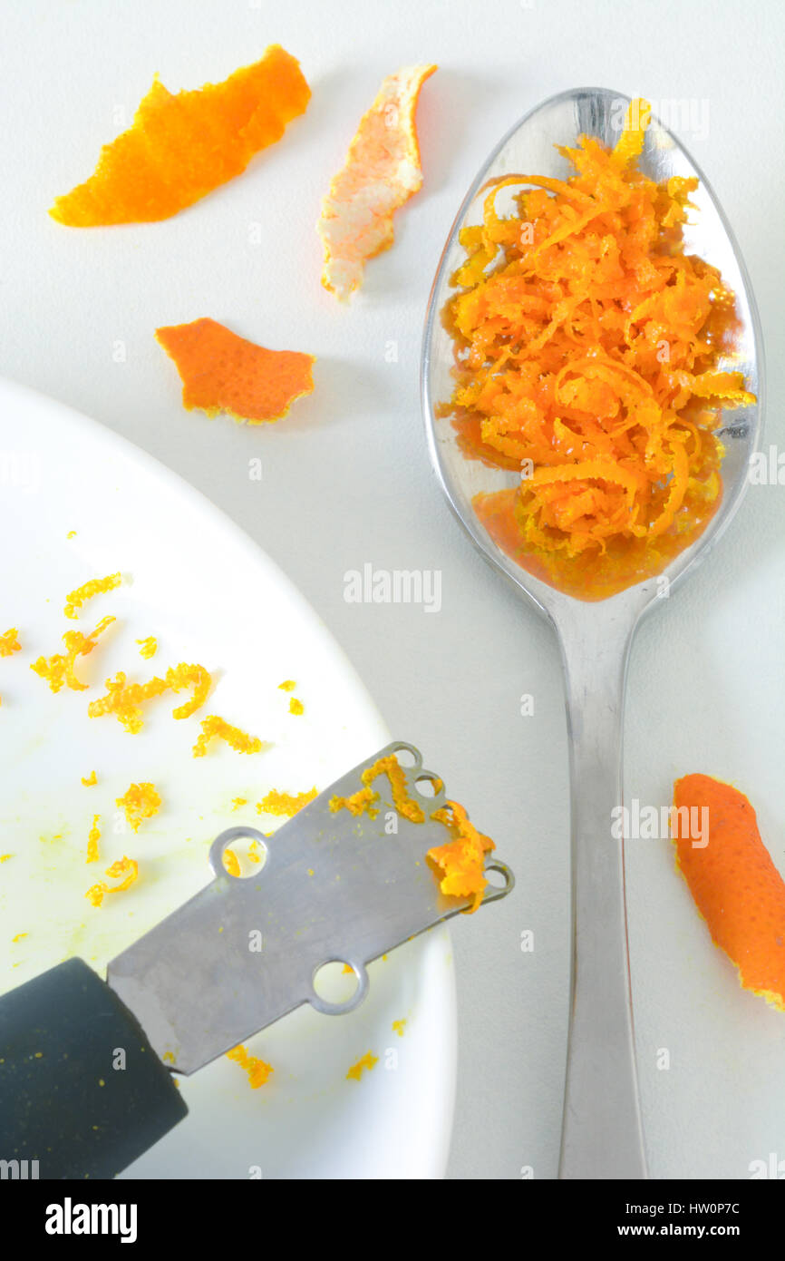 From above closeup view of grated orange zest in a spoon for baking Stock Photo