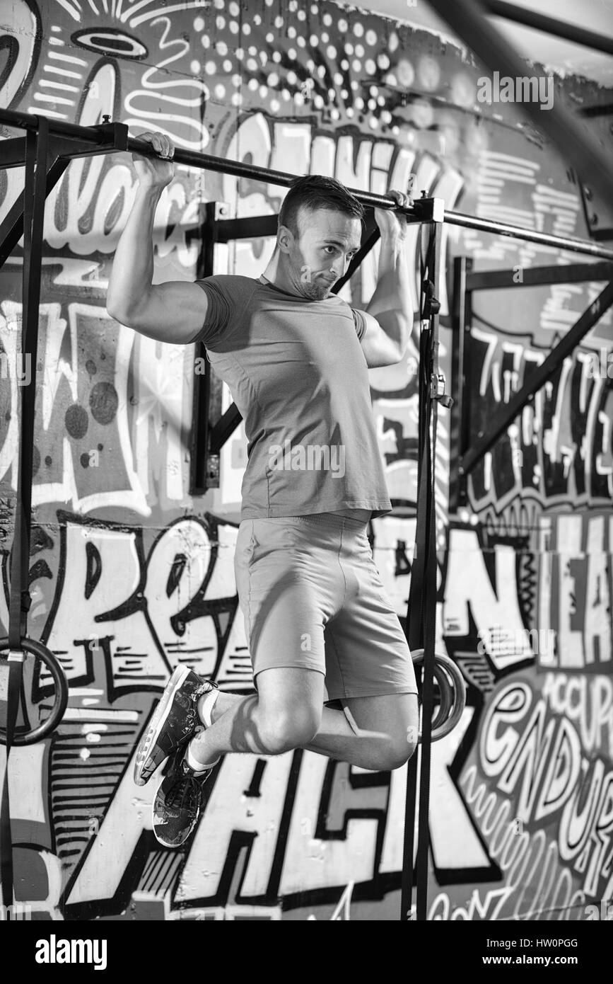 strong young man doing pull ups on a bar in a gym Stock Photo - Alamy