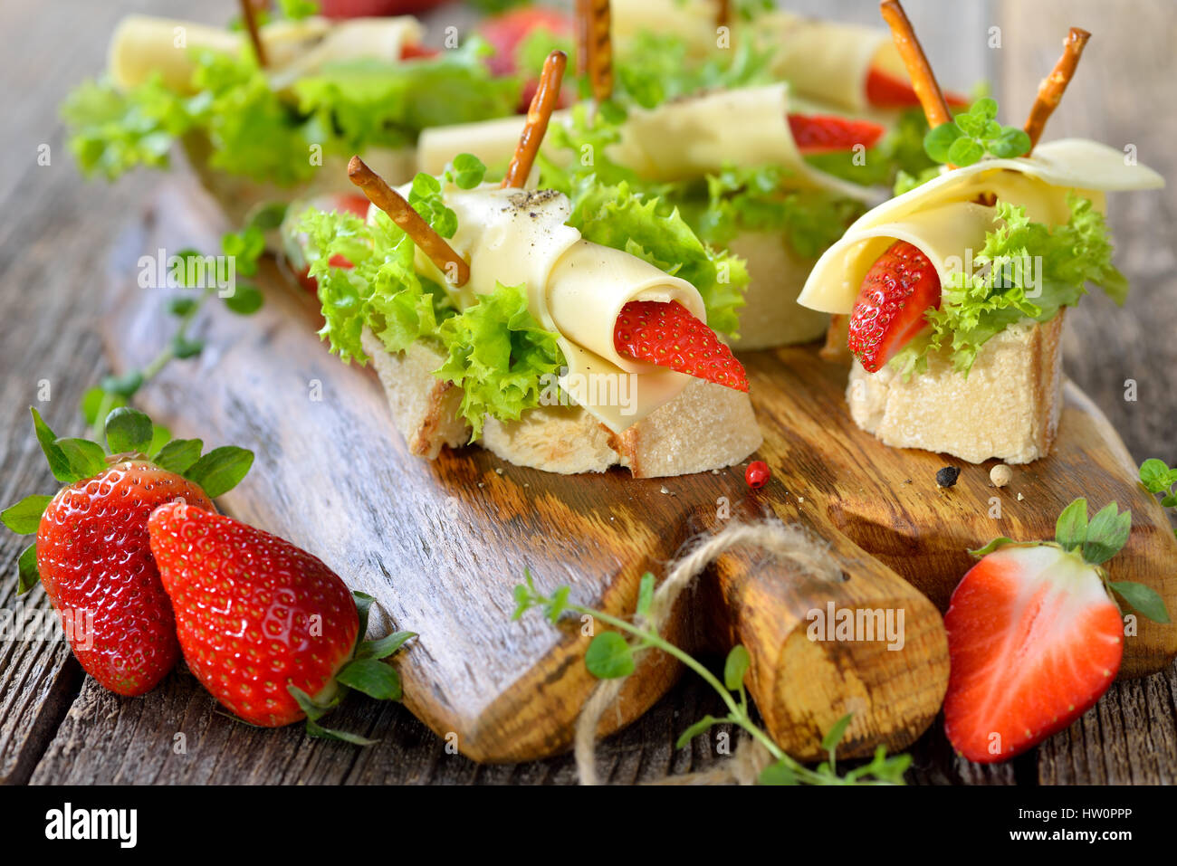 Canapes with delicious cheese rolls and strawberries on Italian