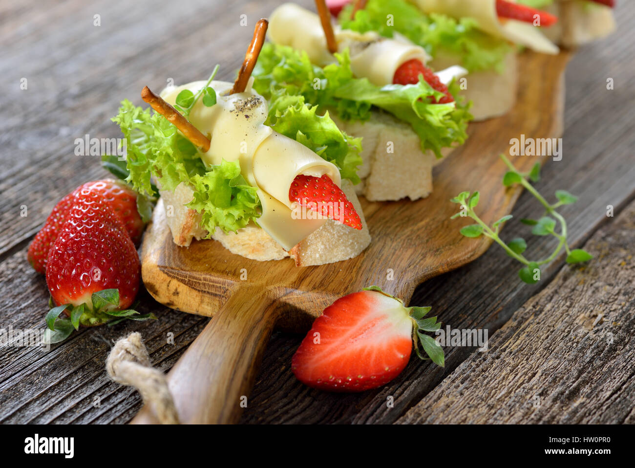 Canapes with delicious cheese rolls and strawberries on Italian