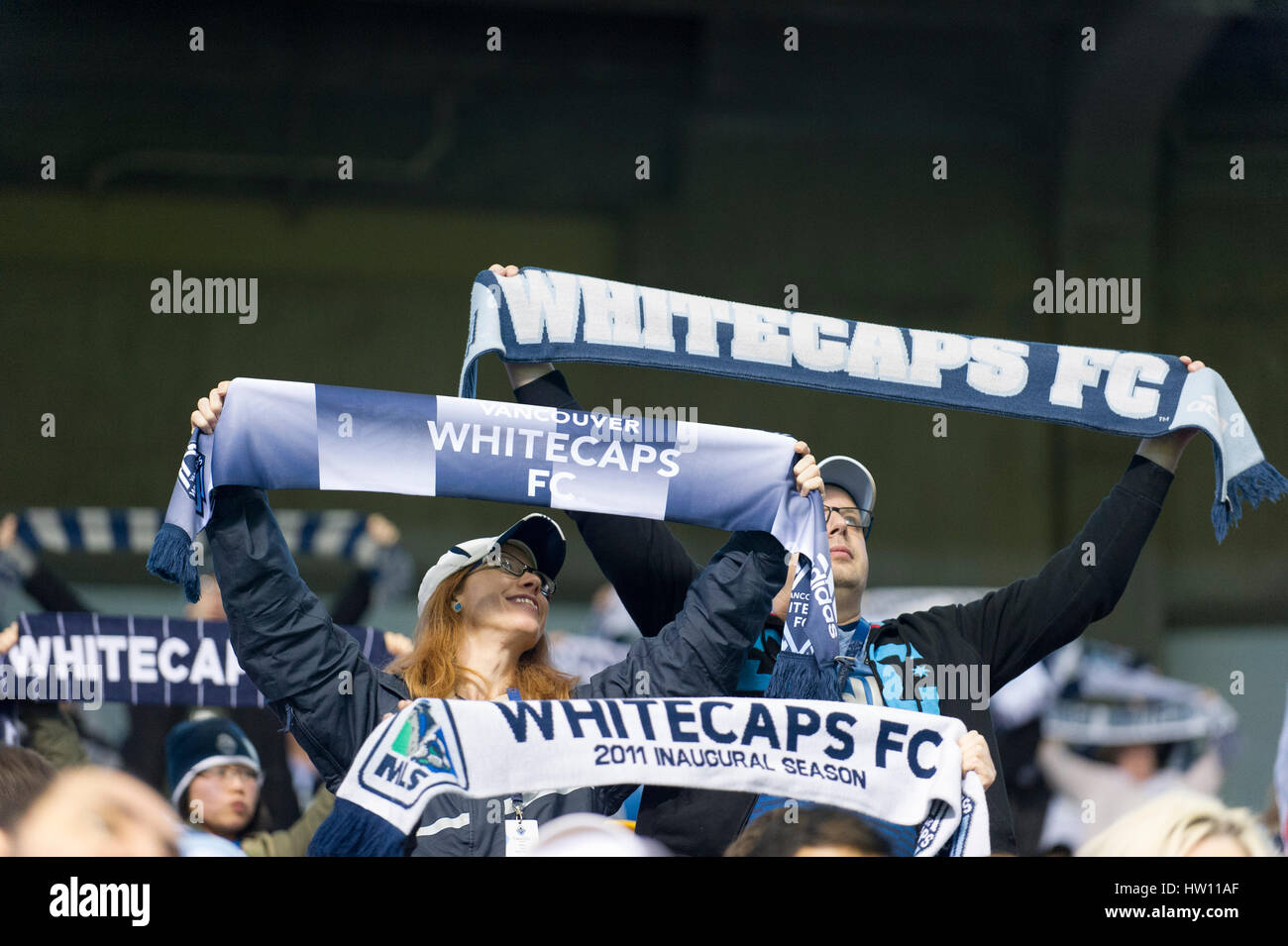 Soccer Sport Fans holding up team scarfs inside a indoor stadium. Stock Photo