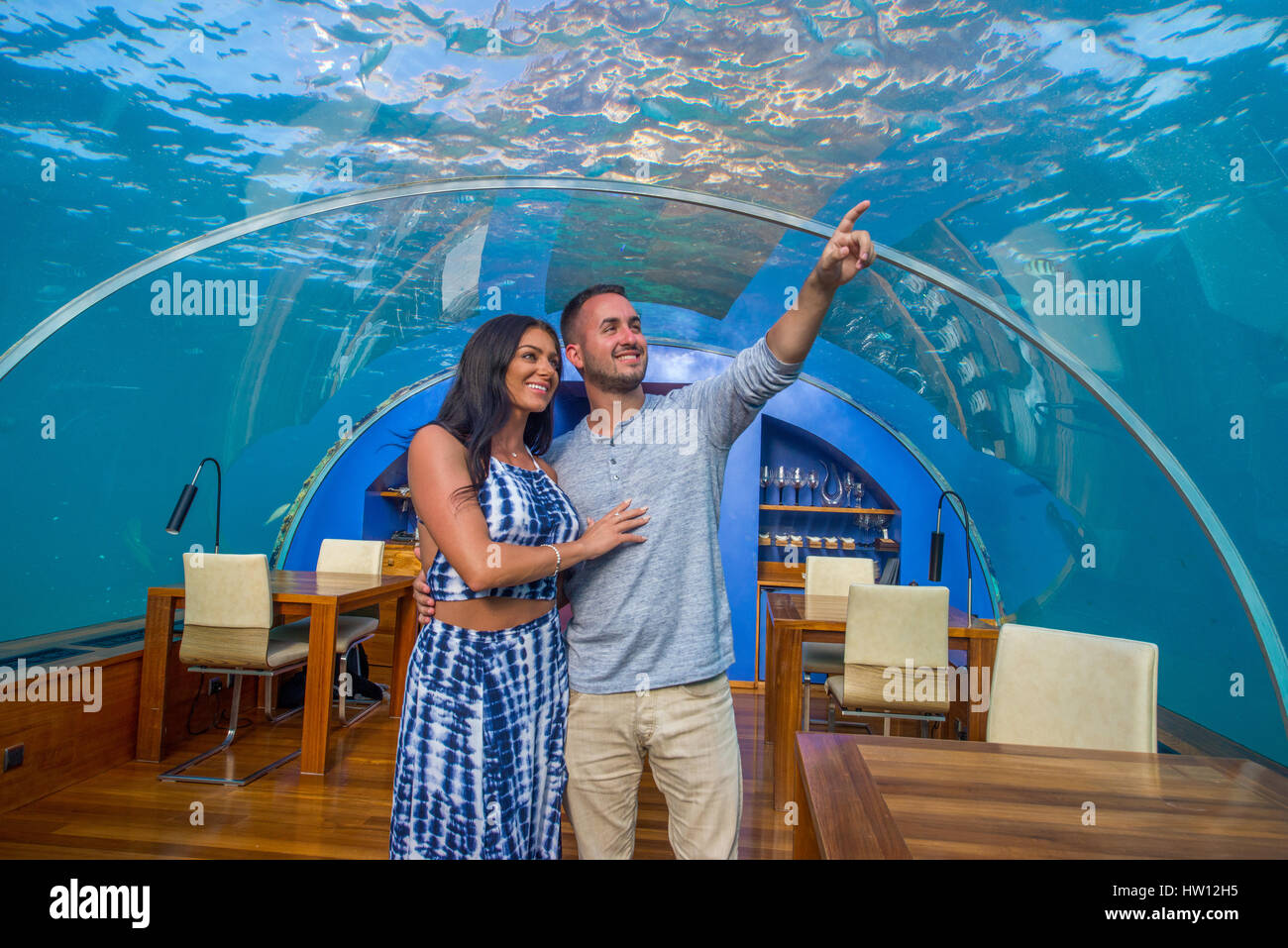 Maldives, Rangali Island. Conrad Hilton Resort. Couple at Ithaa underwater restaurant. (MR) Stock Photo
