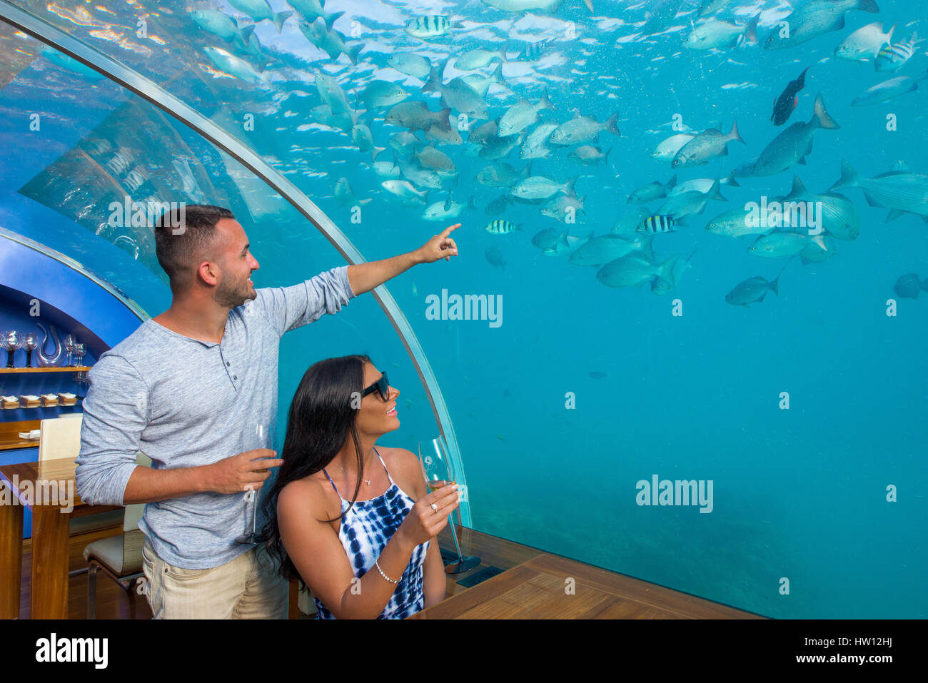 Maldives, Rangali Island. Conrad Hilton Resort. Couple at Ithaa underwater restaurant. (MR) Stock Photo