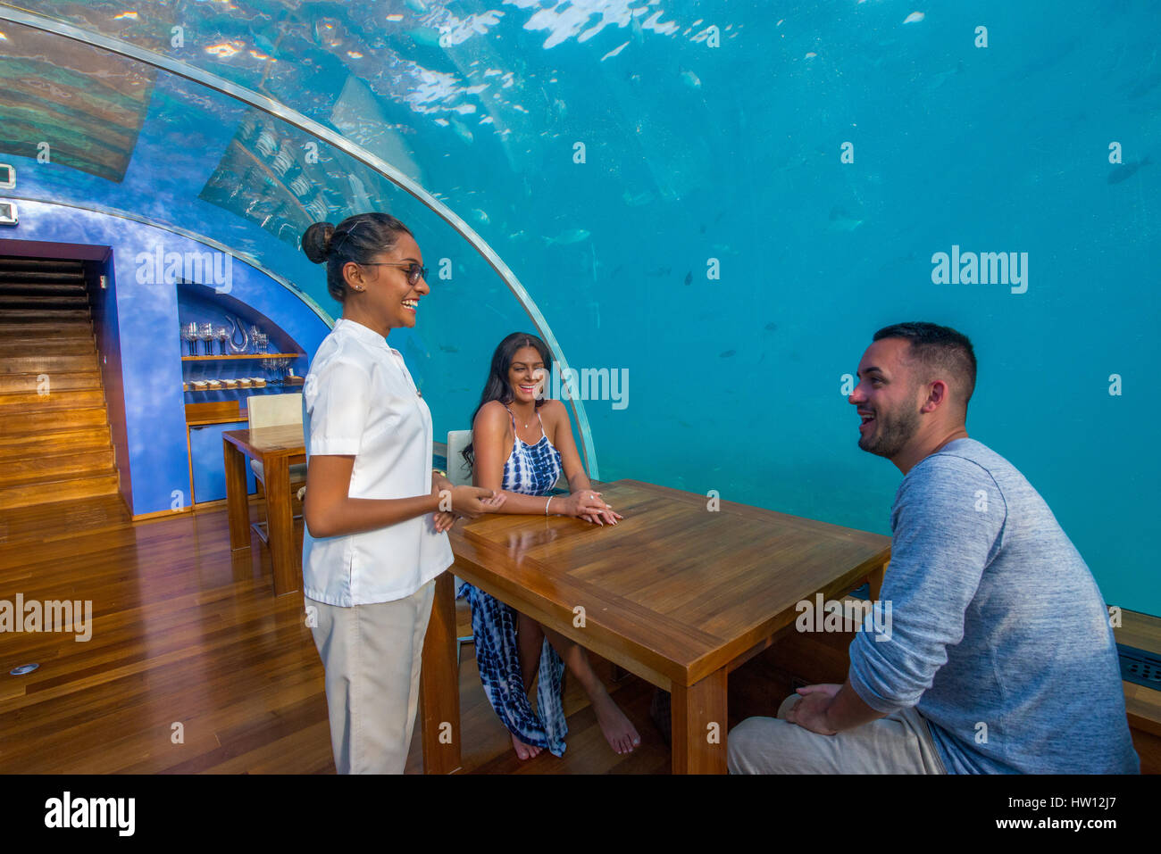 Maldives, Rangali Island. Conrad Hilton Resort. Couple at Ithaa underwater restaurant. (MR) Stock Photo