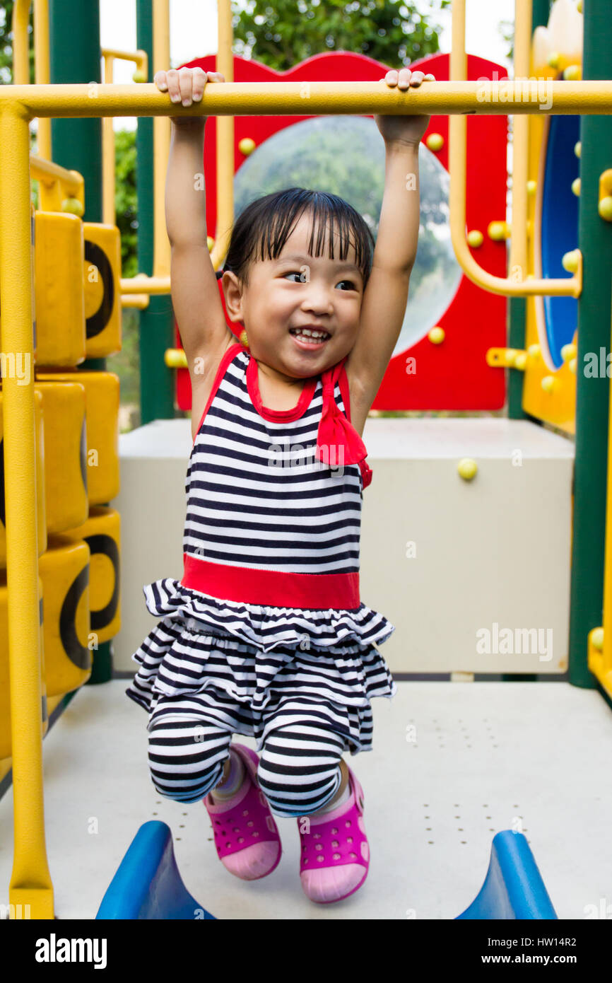Asian Chinese little girl hanging on outdoor playground Stock Photo