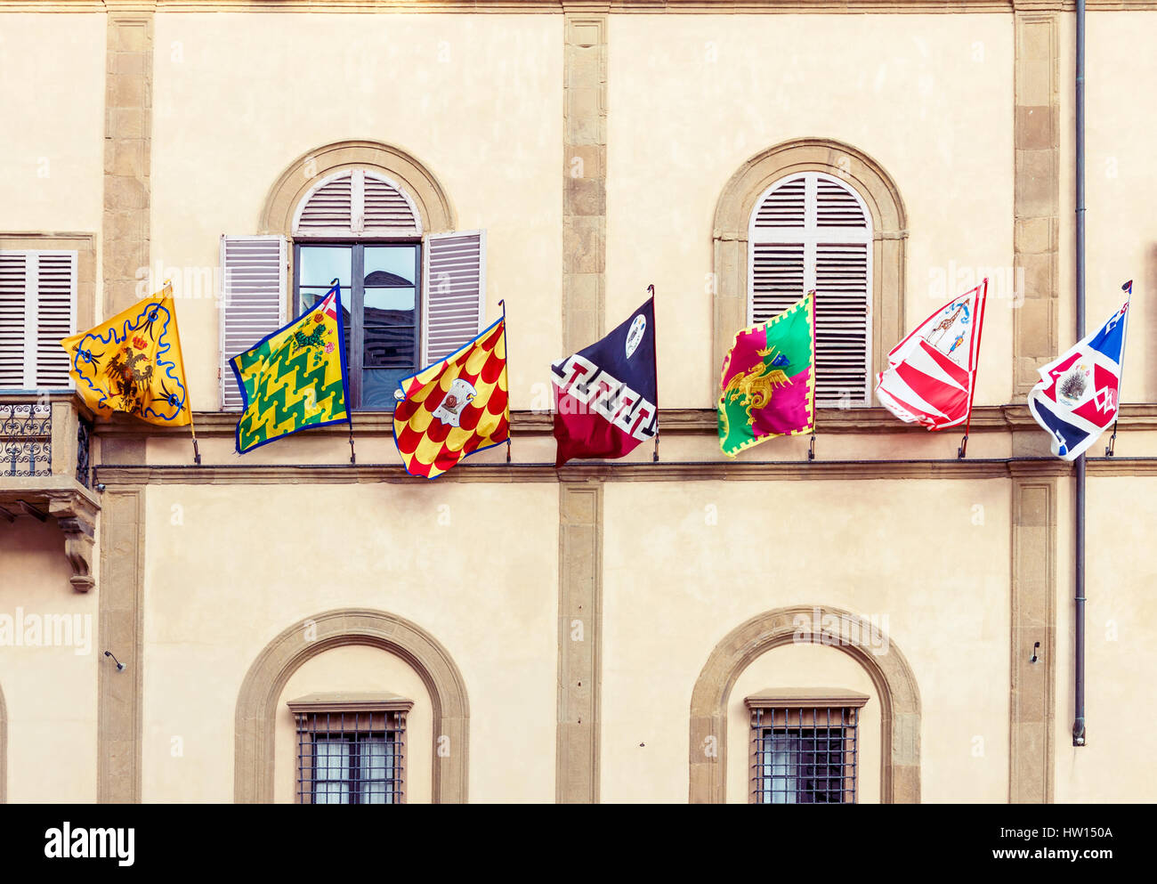 Siena medieval building decorated with district flags during traditional Palio horse race Stock Photo