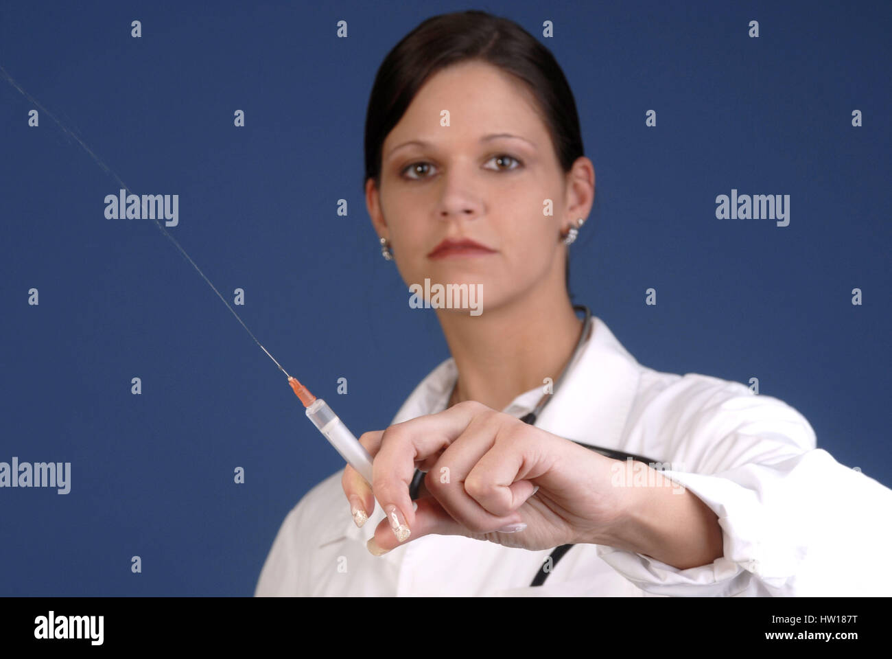 Young doctor holds a syringe in the hand, Junge ƒrztin h‰lt eine Spritze in der Hand Stock Photo
