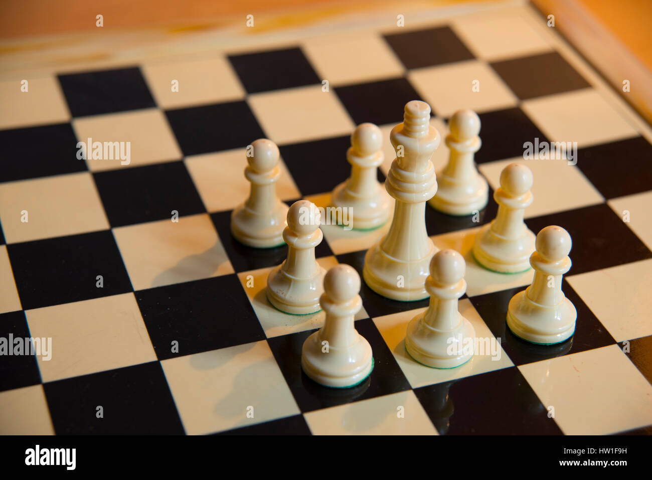 Chess: white king surrounded by white pawns. Stock Photo