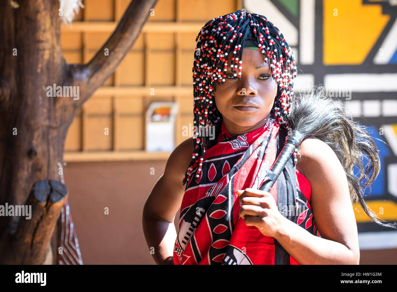 Lesedi Cultural Village, SOUTH AFRICA - 4 November 2016: Young Zulu woman in colouful traditional  costume with beaded hair Stock Photo