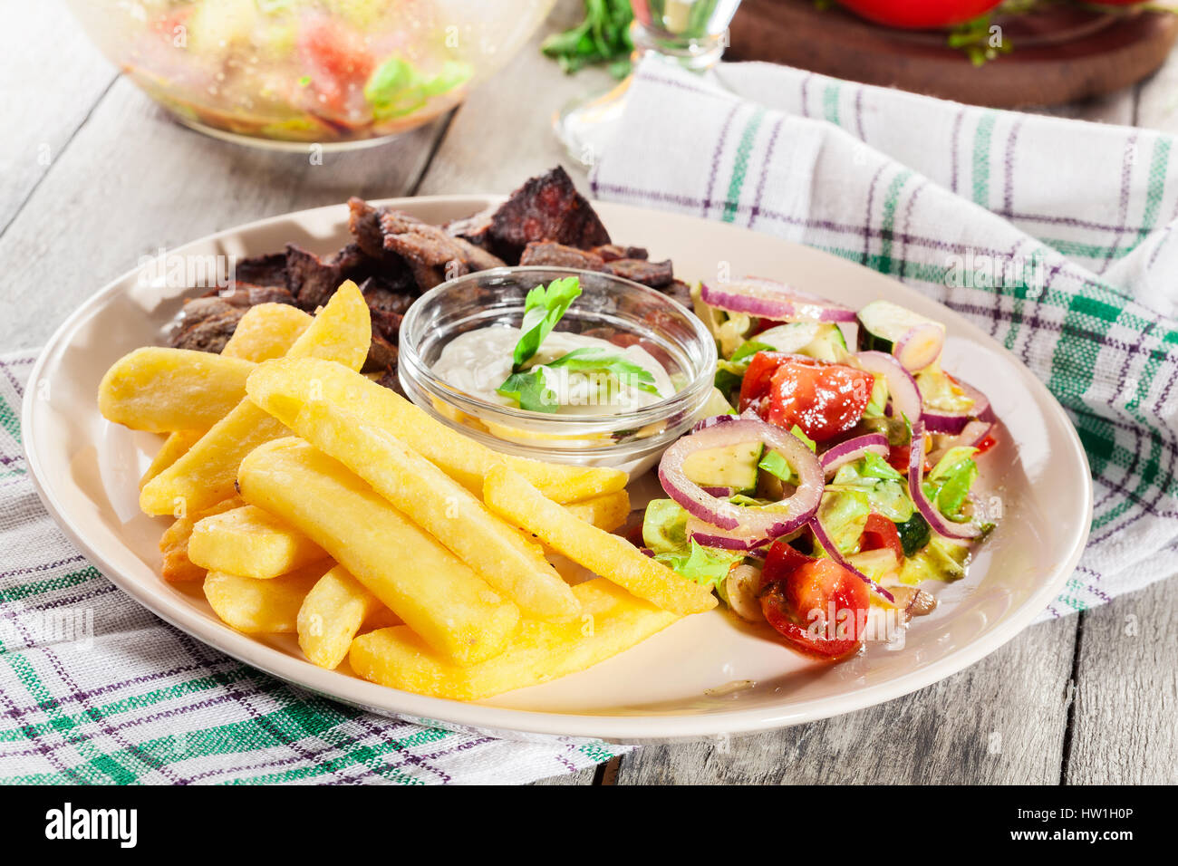 Grilled meat with French fries and fresh vegetables on a plate Stock Photo