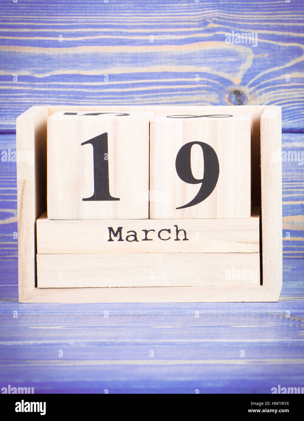 March 19th. Date of 19 March on wooden cube calendar, purple board as