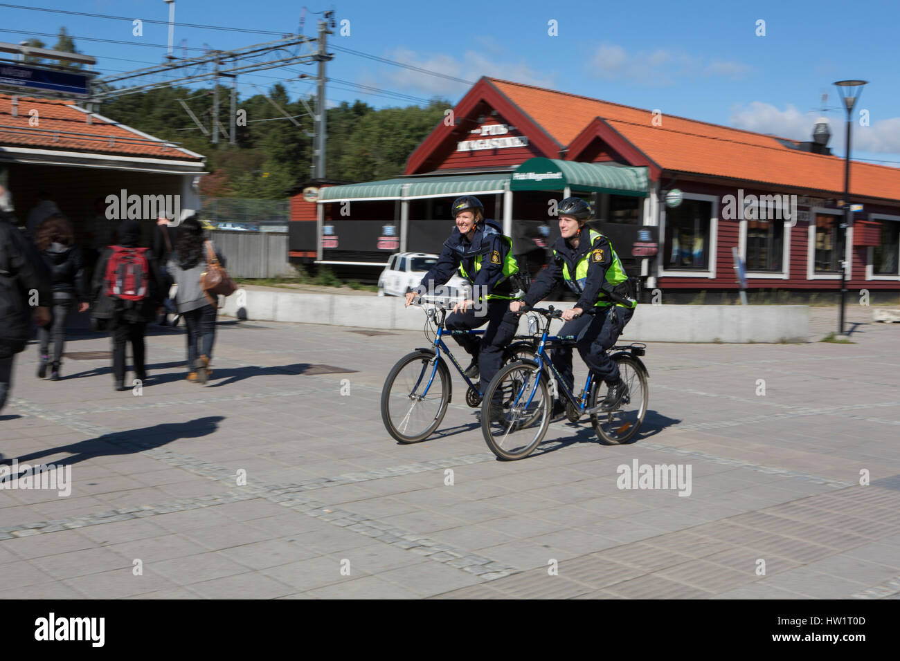 Two female police officers patrolling by bike in Upplands Vasby, Sweden. Stock Photo