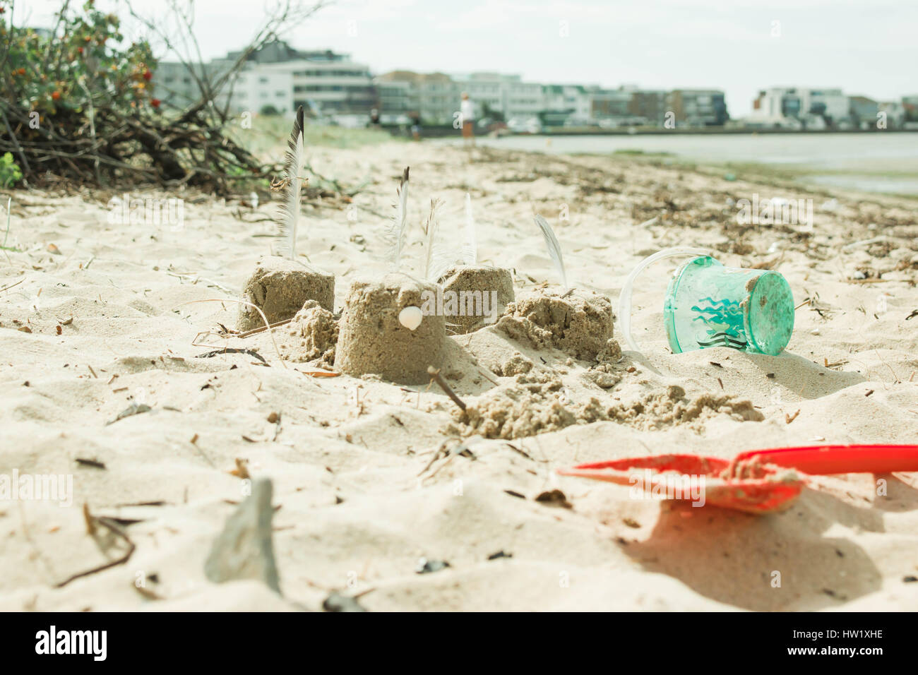 Sandcastles on a beach with spade and bucket. Stock Photo
