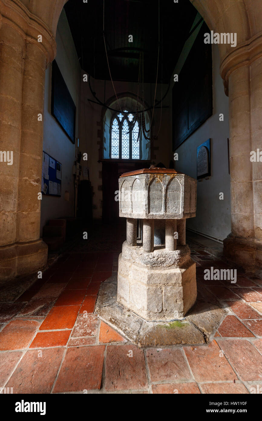 Traditional medieval stone baptismal font, interior of the historic St Peter & St Paul church