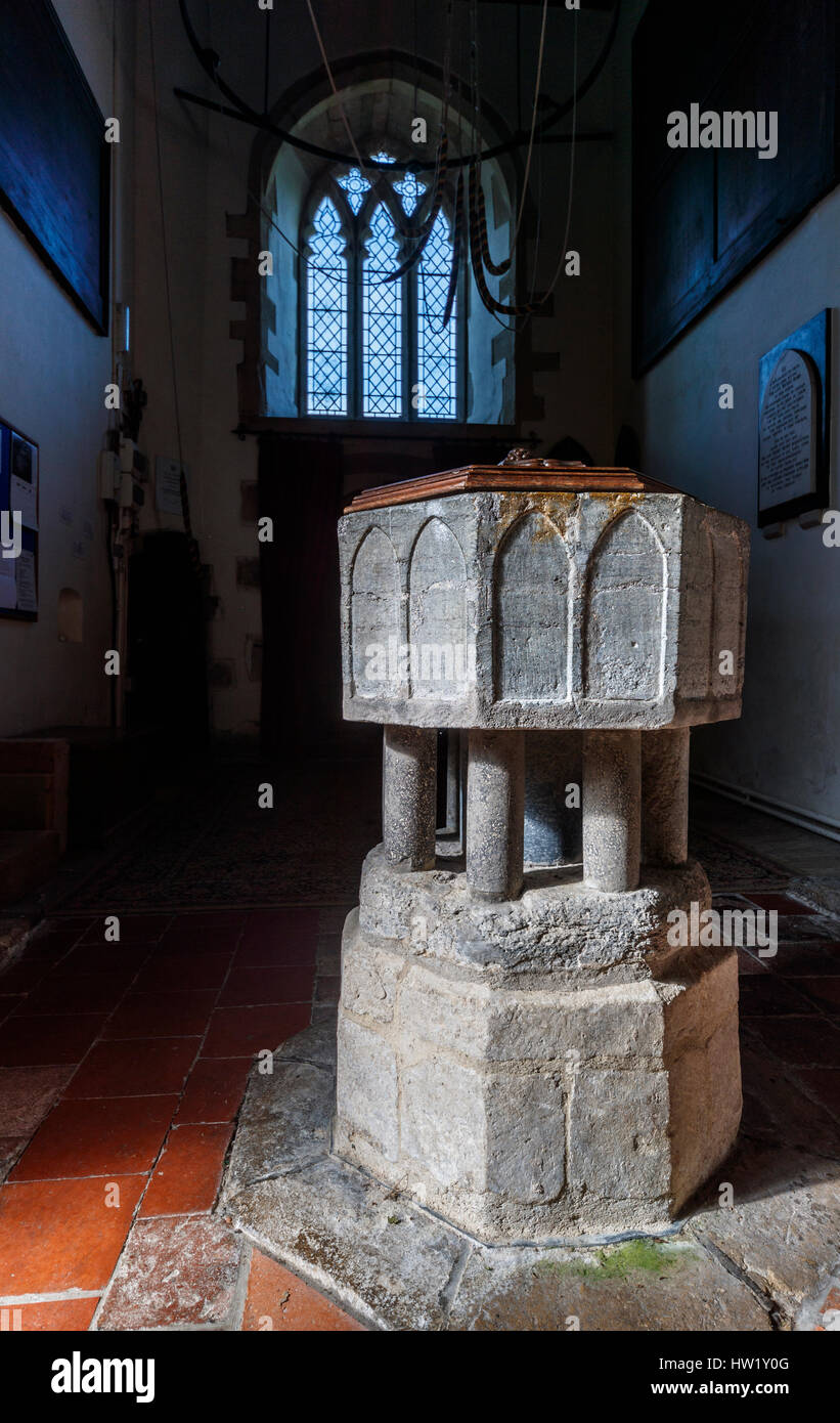 Traditional medieval stone baptismal font, interior of the historic St Peter & St Paul church