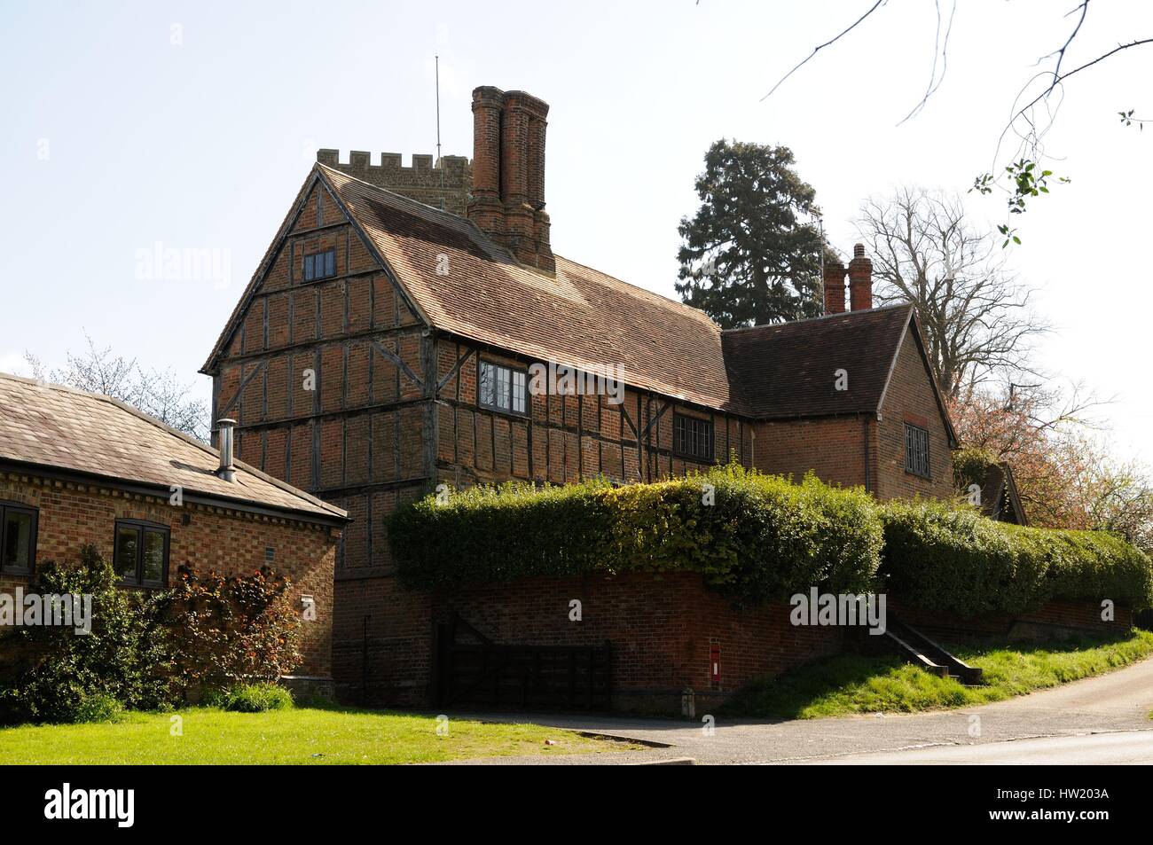 Manor Farm House, Husborne Crawley, Bedfordshire, stands in front of the church is a half-timbered building with brick infilling, and a tall chimney.  Stock Photo