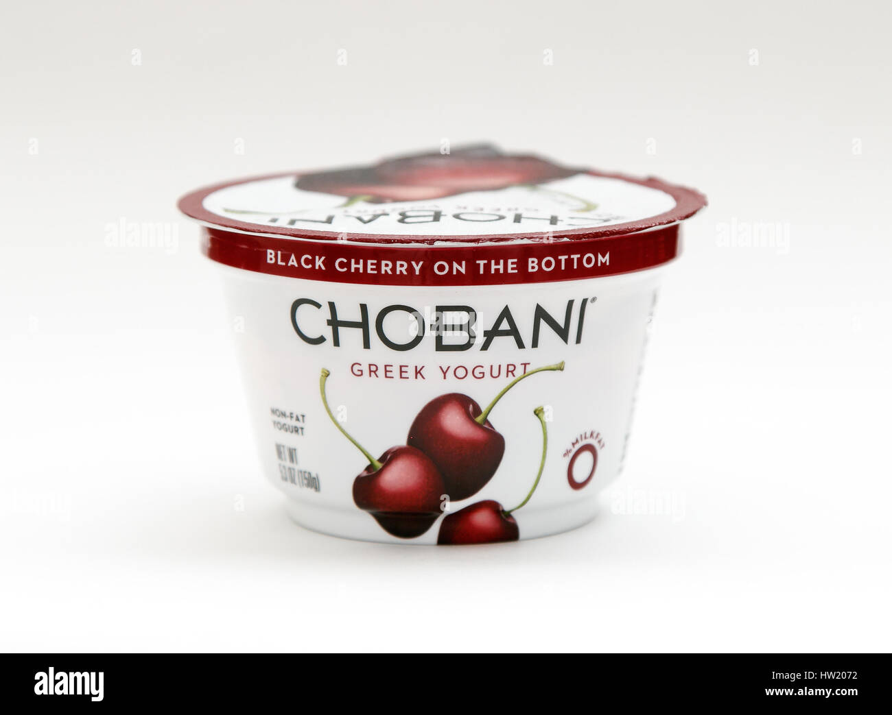 Container of cherry Chobani Greek yogurt stands against white background. Stock Photo