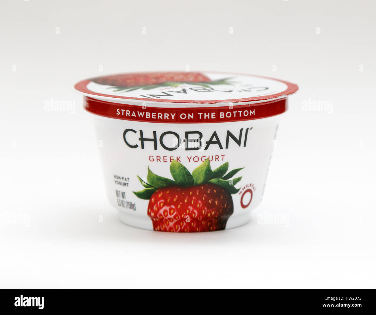 Container of strawberry Chobani Greek yogurt stands against white background. Stock Photo