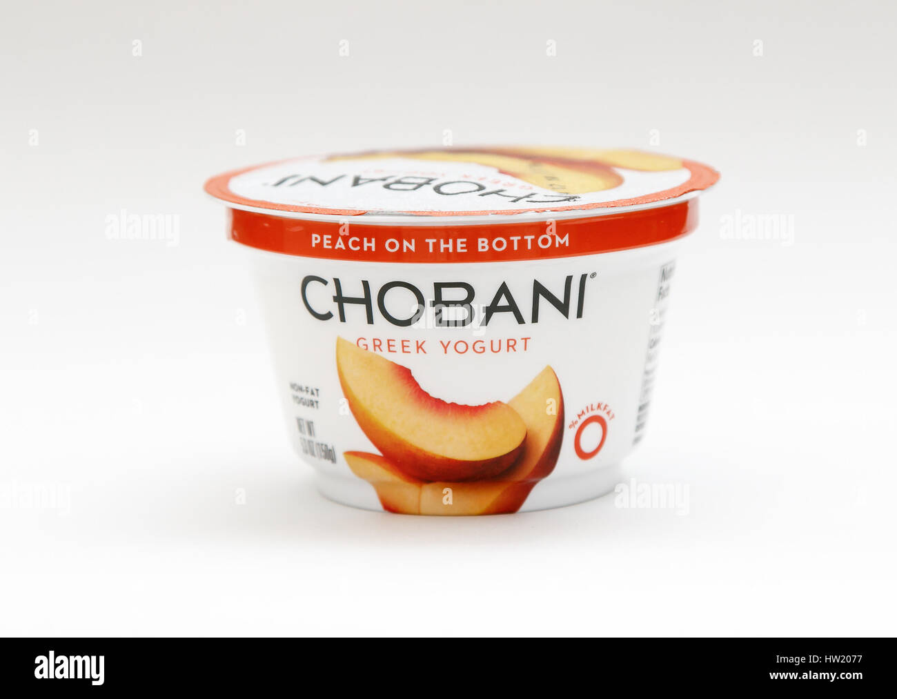 Container of peach Chobani Greek yogurt stands against white background. Stock Photo