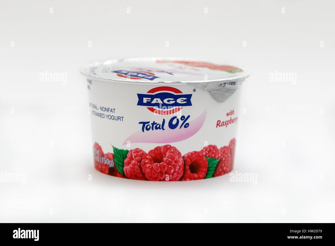 Container of raspberry Fage yogurt stands against white background. Stock Photo