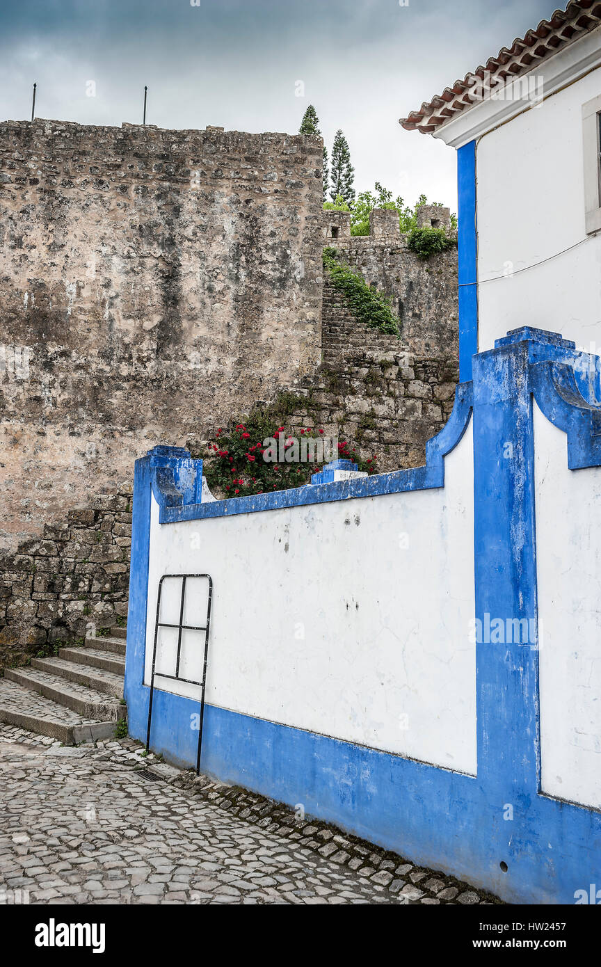 Portugal, Obidos - urban village and the castle of the same name with the fortress. Cobbled stone streets , stairs and an abundance of decorative flow Stock Photo