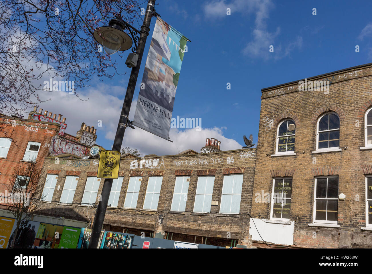 Construction and regeneration hoardings featuring local arts and community on 7th March 2017, on Station Square, Railton Road in Herne Hill, SE24, London borough of Lambeth, England. The small Victorian-era shops in Station Square, Herne Hill is undergoing a regeneration of its railway arches and local businesses have been closed by their Network Rail owners, part of the gentrification of the area which has attracted opposition and controversy. Stock Photo