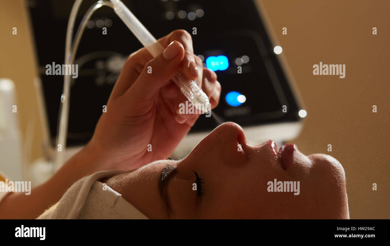 Face Beauty Treatment. Closeup Of Beautiful Woman Getting Facial Gas-liquid Oxygen Water Epidermal Peeling Using Professional Equipment At Cosmetology Center. Skin Care Concept. Stock Photo