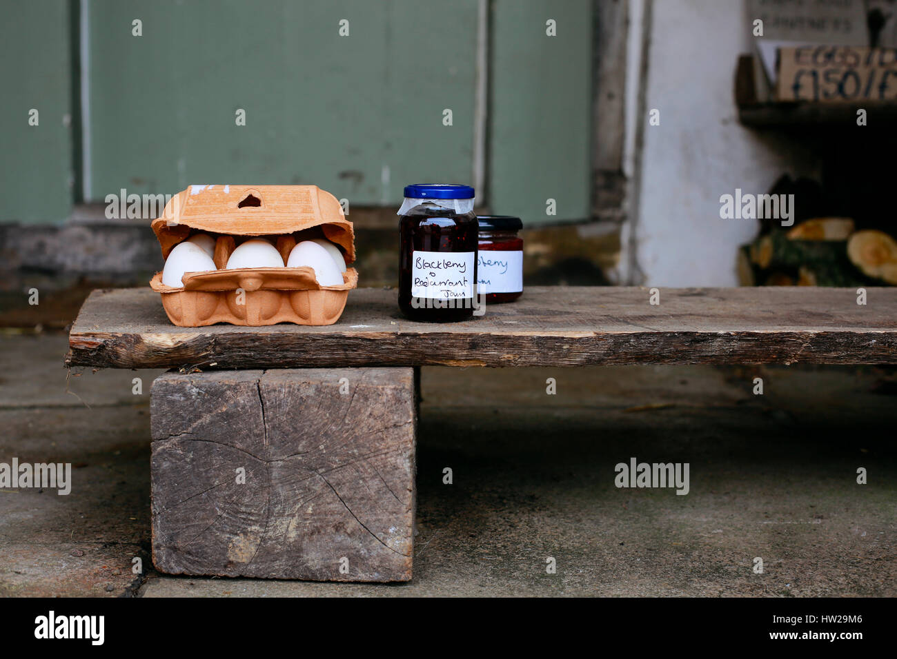 Eggs and homemade jam for sale on the porch of a house in small village of Lacock, England. Buyers are asked to pay for products into honesty box. Stock Photo