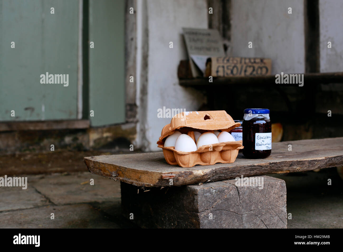 Eggs and homemade jam for sale on the porch of a house in small village of Lacock, England. Buyers are asked to pay for products into honesty box. Stock Photo