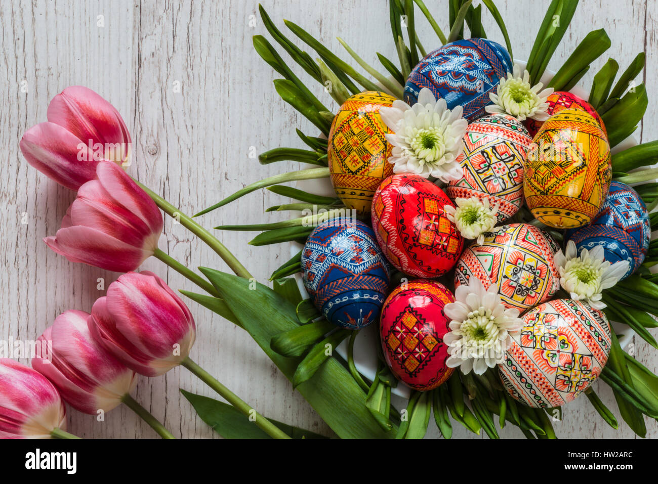 Easter Background with easter eggs and pink tulips on light wooden ...