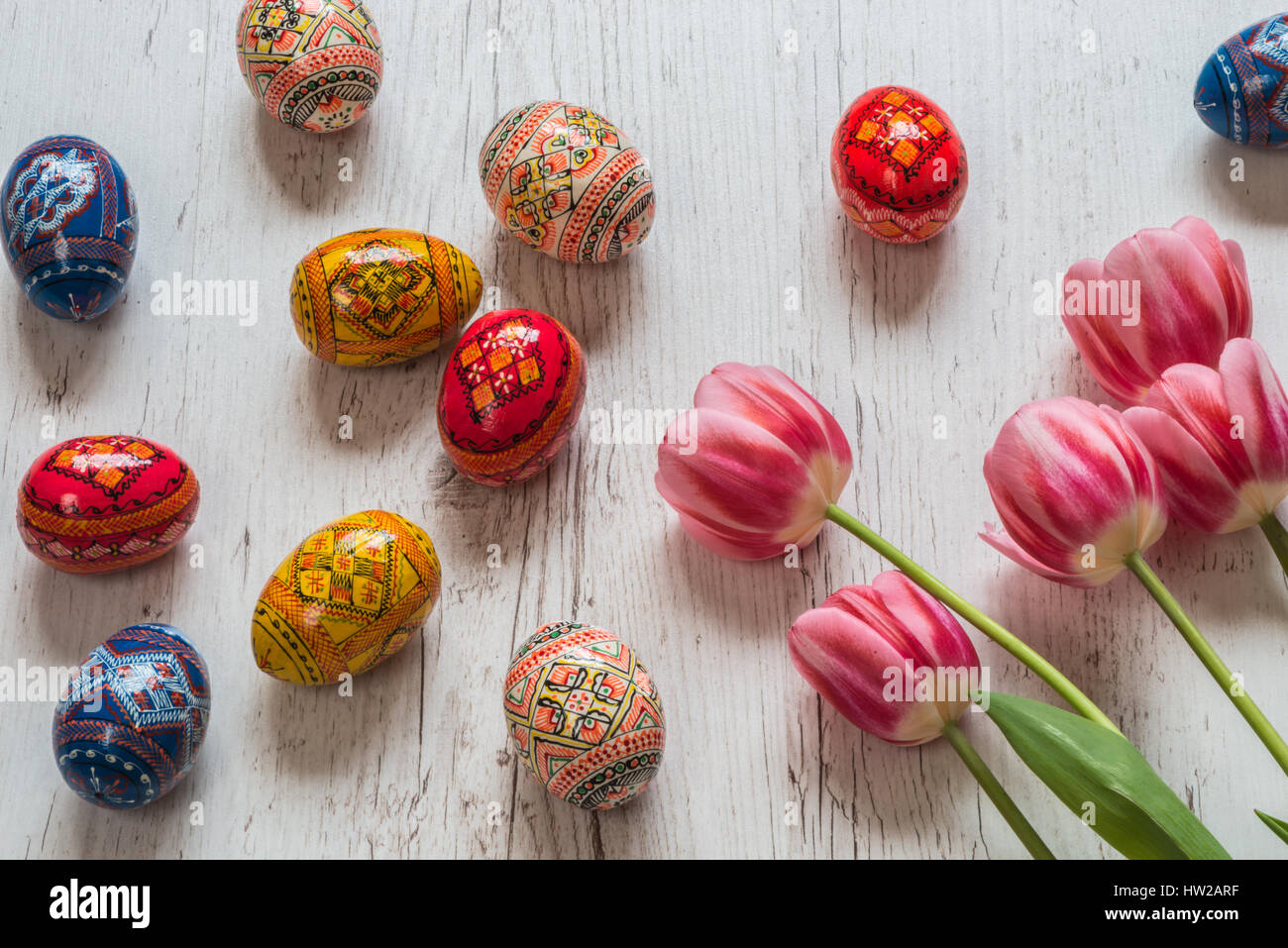 Easter Background with easter eggs and pink tulips on light wooden ...