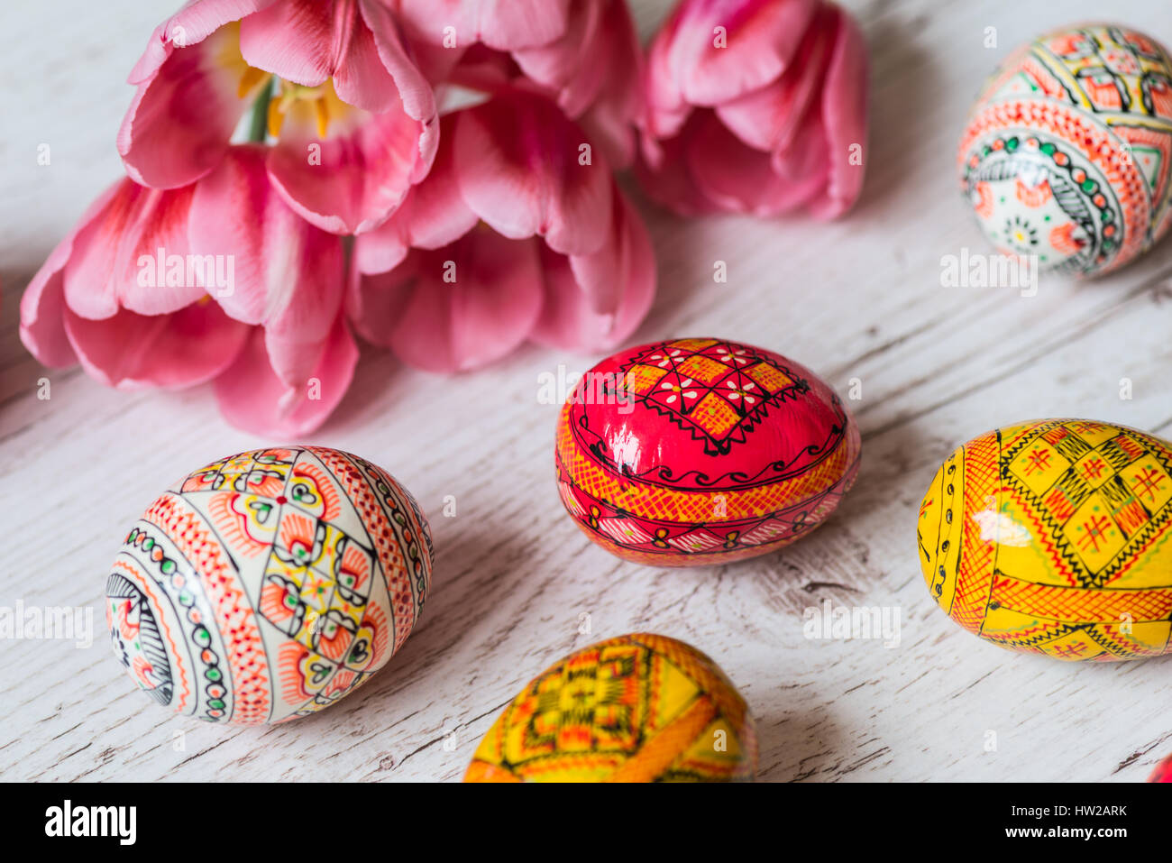 Easter Background with easter eggs and pink tulips on light wooden ...