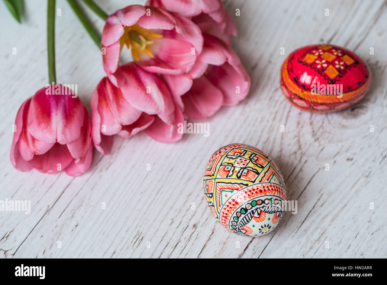 Easter Background with easter eggs and pink tulips on light wooden ...