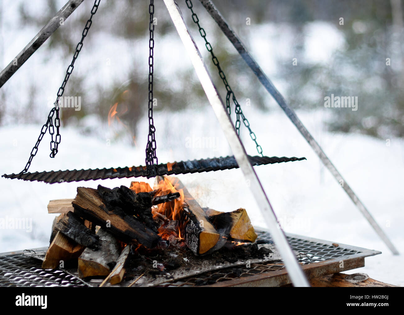 Closup of a construction for cooking in nature in winter on a burning fire, picture from the North of Sweden. Stock Photo