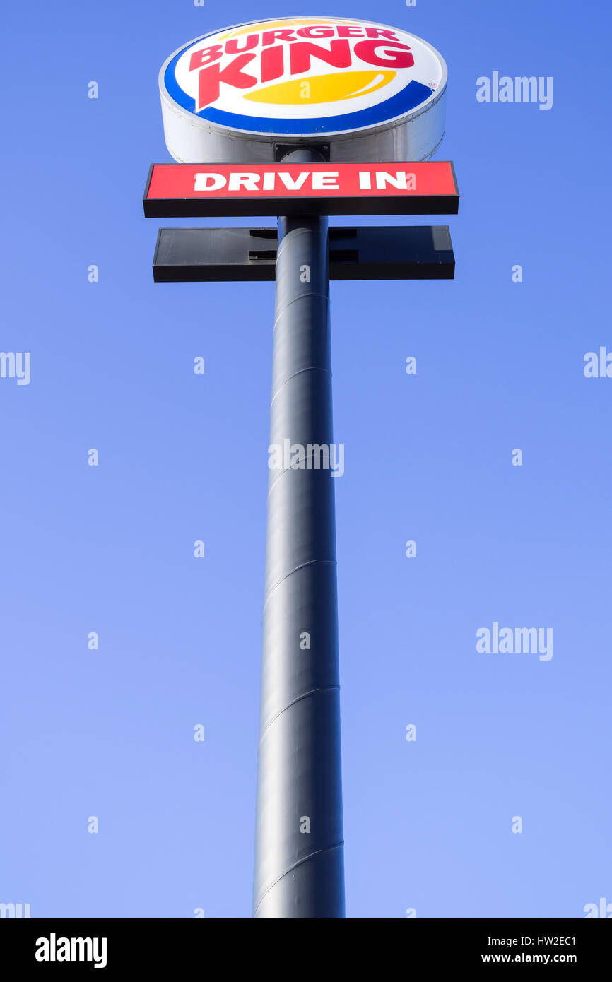 Burger King signpost against blue sky.  Burger King is the second largest chain of hamburger fast food restaurants in terms of global locations. Stock Photo