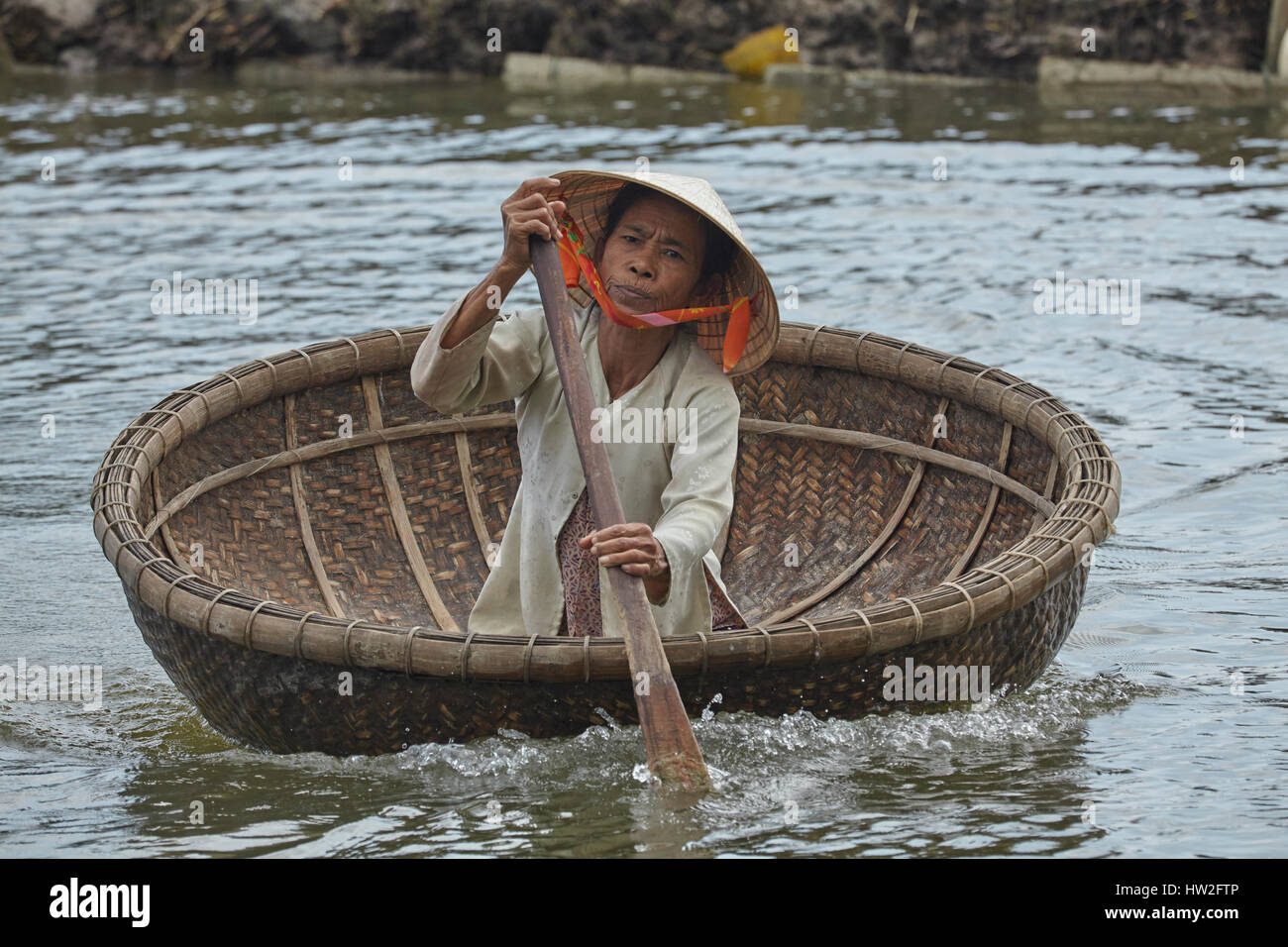 Elderly woman in basket boat, Cam Kim Island, Hoi An, Vietnam Stock Photo