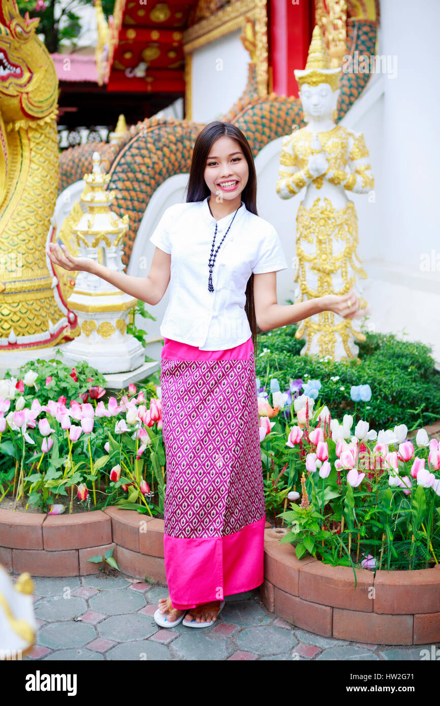 Smiling Asian woman standing in ornate garden Stock Photo