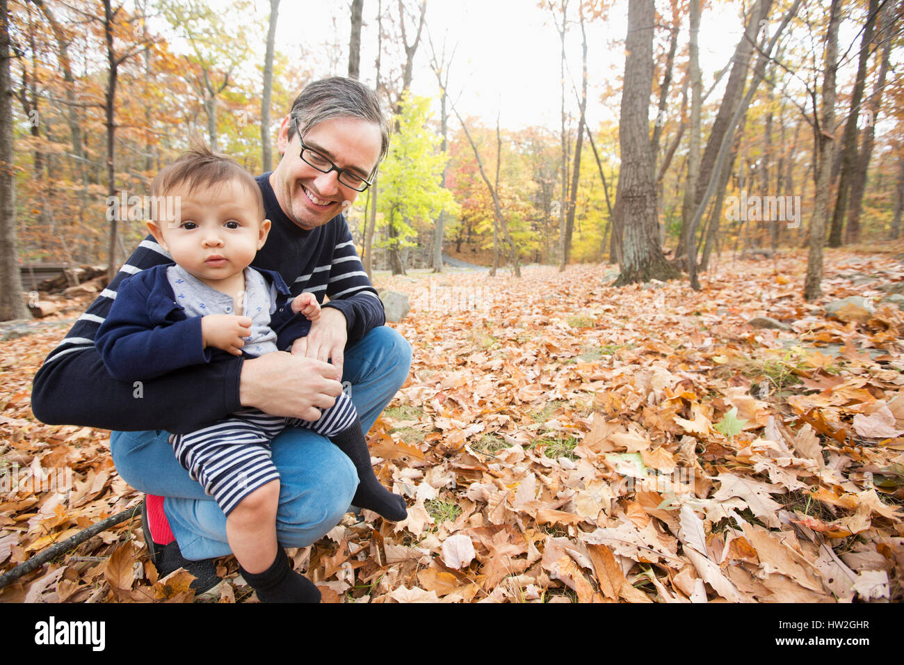 Father holding baby son outdoors in autumn Stock Photo
