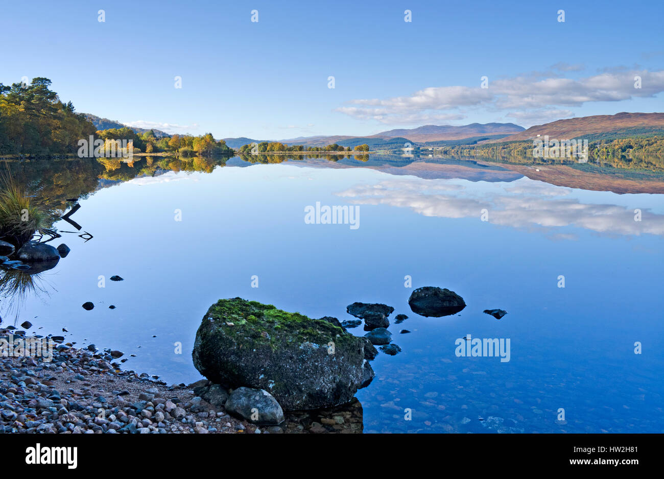 View over the western end of Loch Rannoch, Highland Perthshire, hillsides and woodlands reflected in the calm water on a beautiful autumn day Stock Photo