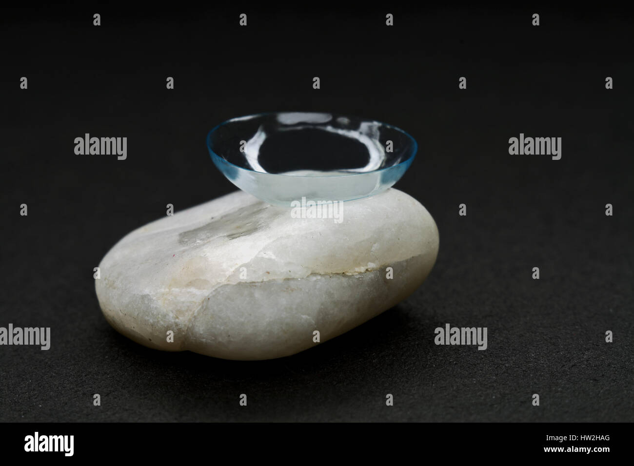 Contact lens on a piece of a granite-combination of fragility and hardness. Stock Photo