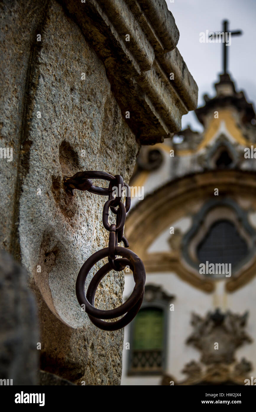 Iron handcuffs used to torture slaves in front of a church Stock Photo